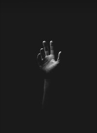 a black and white image of a hand reaching out