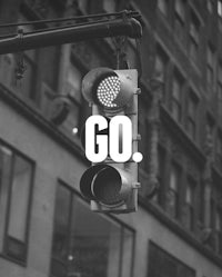 a black and white photo of a traffic light with the word go